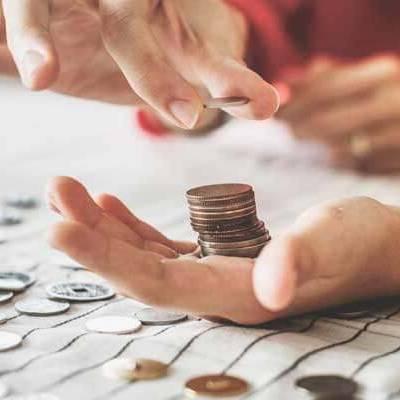 closeup of hands stacking coins and counting change